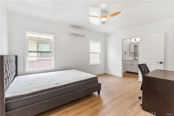 a bedroom with a bed and wooden floor
