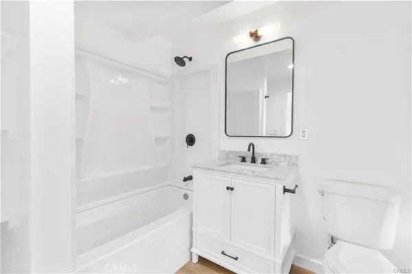 a bathroom with a bathtub sink vanity and toilet