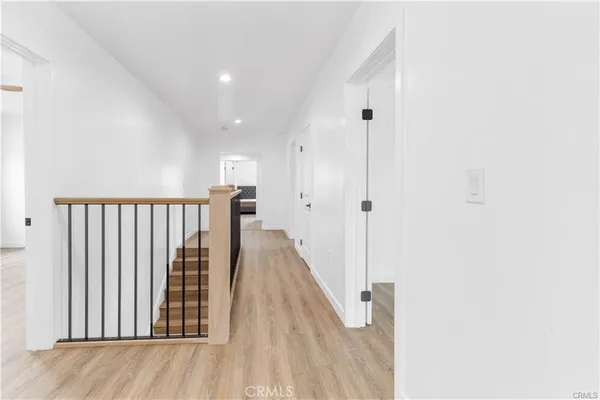 a view of a hallway with wooden floor and staircase