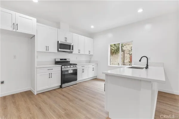 a kitchen with white cabinets and appliances