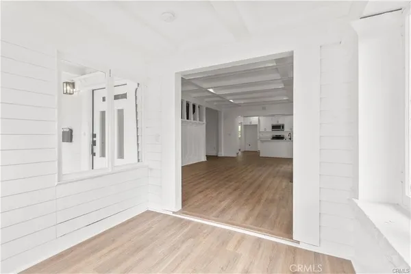 a view of a hallway with wooden floor and a bathroom