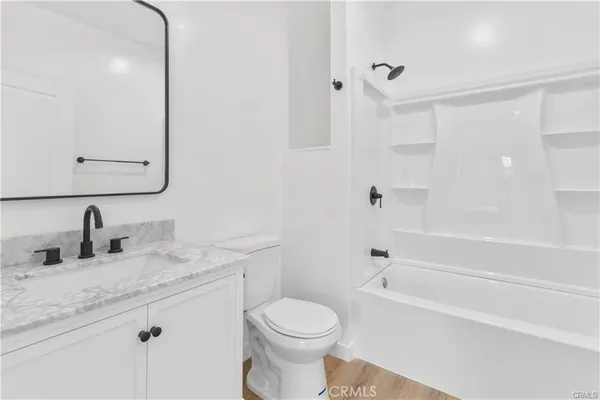 a bathroom with a granite countertop toilet sink and mirror