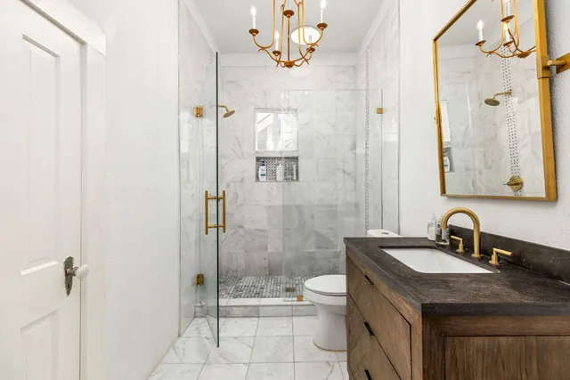 a bathroom with a sink toilet a mirror and shower