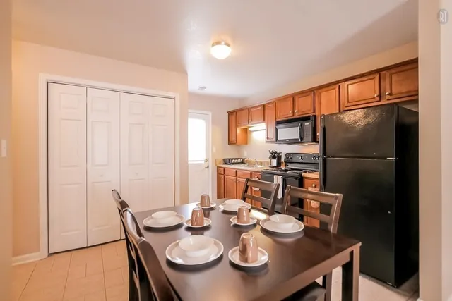 a kitchen with stainless steel appliances granite countertop a dining table and chairs