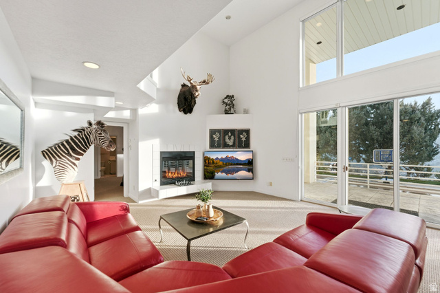 1878 East Ridge Point Drive Bountiful, UT 84010 - Photo 47 of 92 Carpeted living room with a tile fireplace, recessed lighting, and a high ceiling