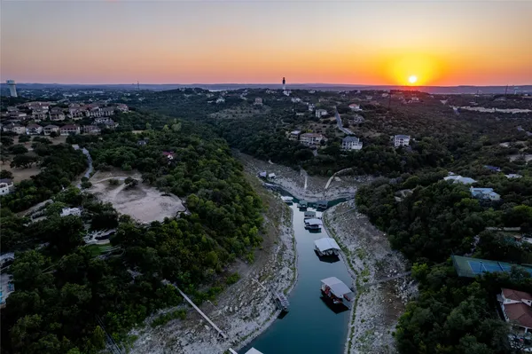 a view of a lake with sunset in background