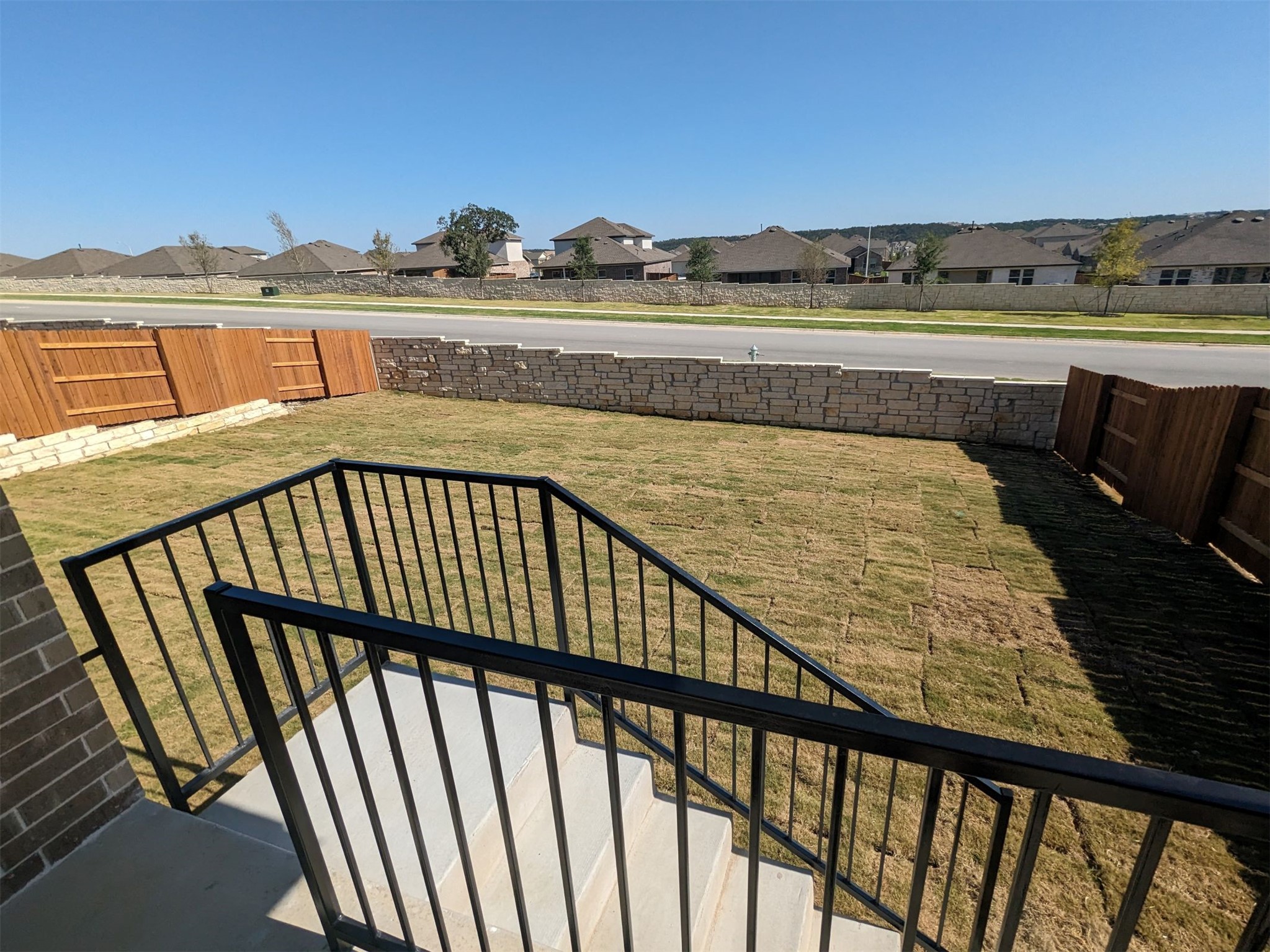 2412 Lightning View Leander, TX 78641 - Photo 22 of 24 A newly sodded lawn, bordered by a privacy fence and stone wall, offers clear neighborhood views.