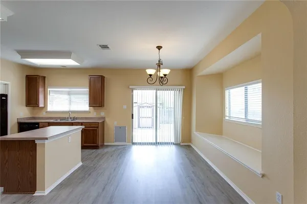 a large kitchen with cabinets wooden floor and stainless steel appliances