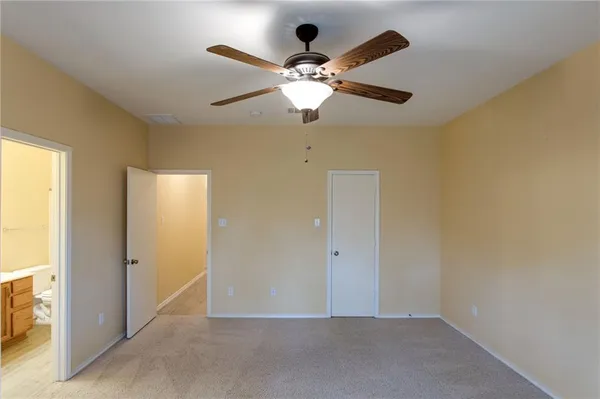 an empty room that has a window and a ceiling fan