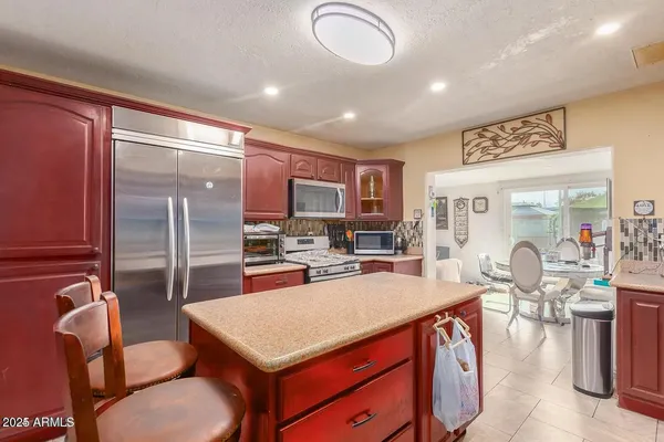 a kitchen with stainless steel appliances granite countertop a sink stove and refrigerator