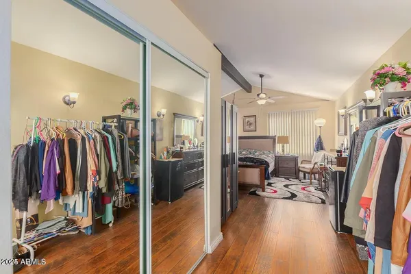 a view of walk in closet with clothes and shoes