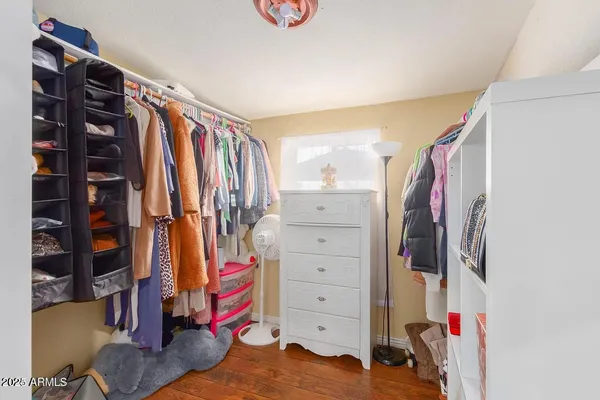 a view of walk in closet with clothes and shoes