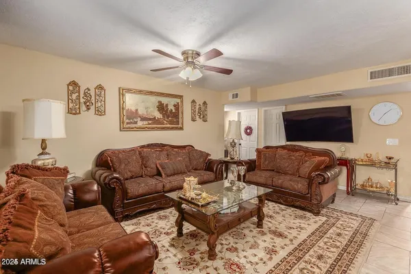 a living room with furniture ceiling fan and a rug