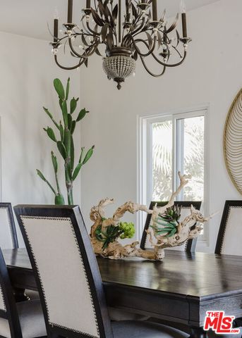 a dining room with furniture potted plants and a chandelier