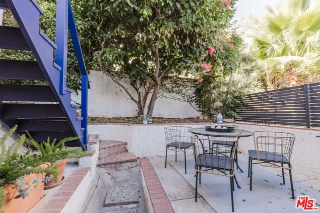 a view of backyard with a table and chairs and potted plants