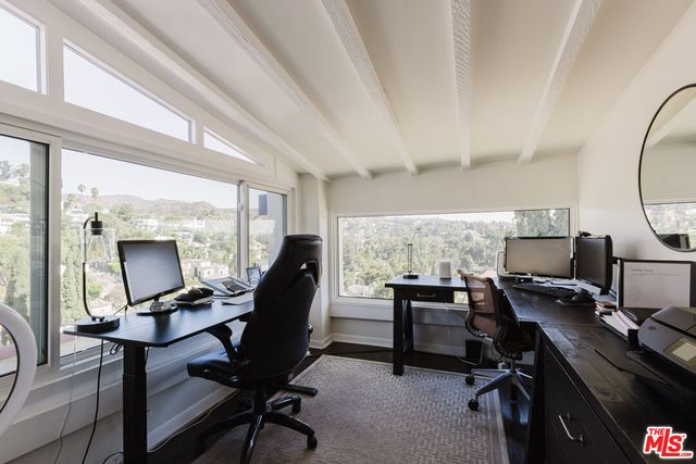 a view of a workspace with furniture and a window