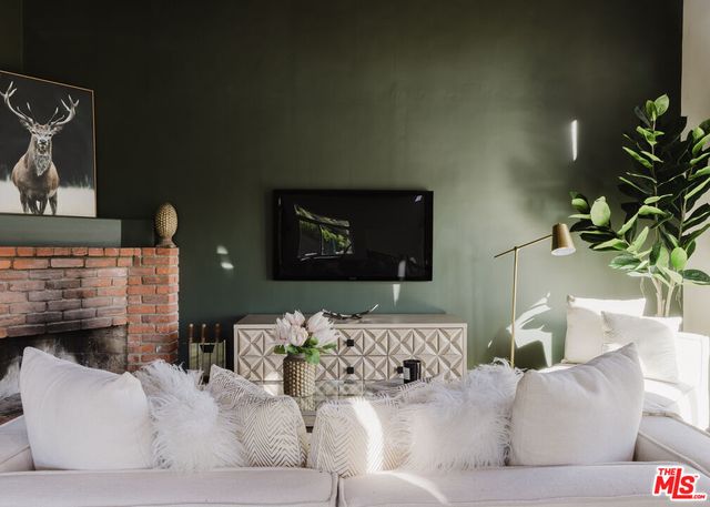 a living room with furniture stairs and a potted plant