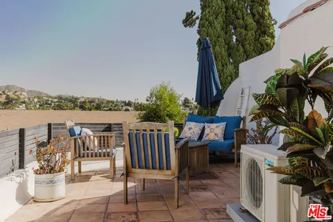 a balcony with furniture and potted plants