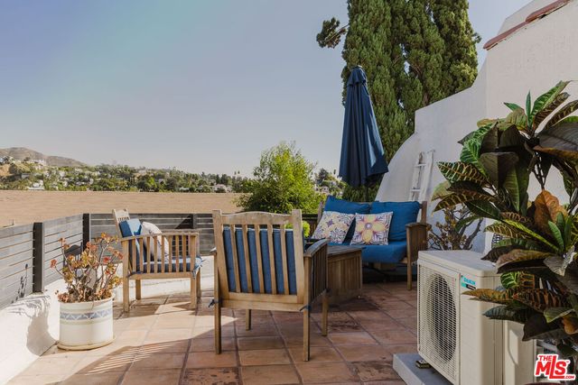 a balcony with furniture and potted plants