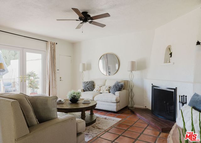 a living room with furniture a fireplace and a floor to ceiling window
