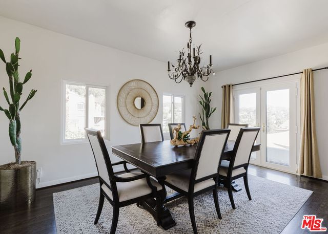 a dining room with furniture a potted plant and wooden floor