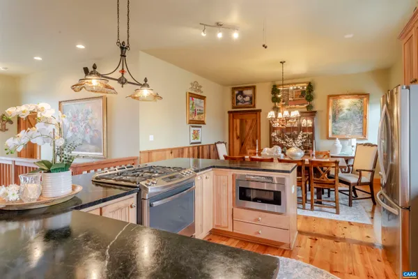 a dining room with furniture a chandelier and wooden floor