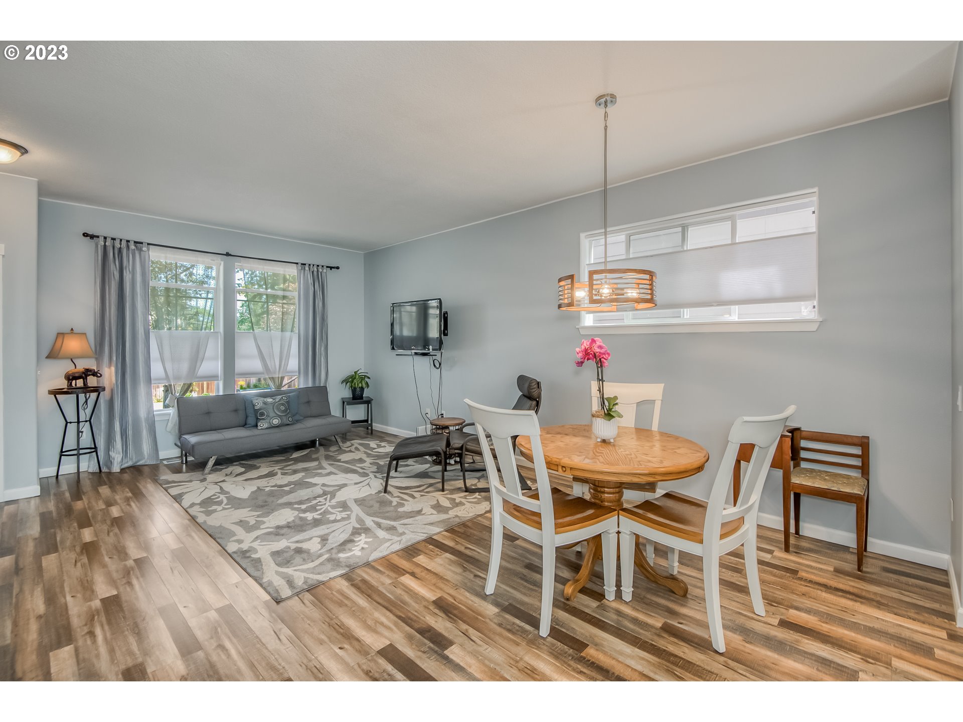 18074 Southwest Lotus Lane Beaverton, OR 97003 - Photo 6 of 19 a dining room with furniture a chandelier and wooden floor