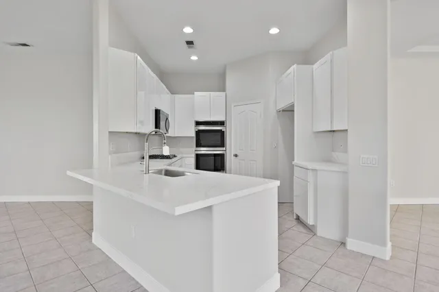 a kitchen with white cabinets and sink