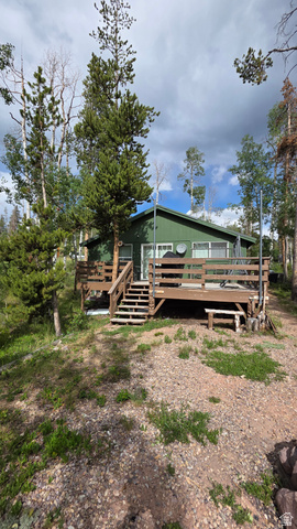 5782 Pineview Loop, Unit 921 Kamas, UT 84036 - Photo 2 of 29 Green-sided residence with a brown wood deck, featuring white-framed windows and a green shingle roof