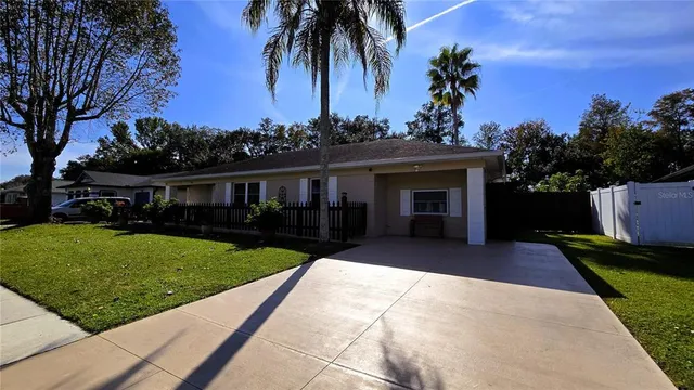a front view of a house with a garden and trees