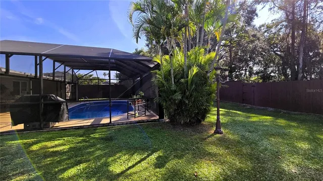 a view of a house with a big yard plants and large trees