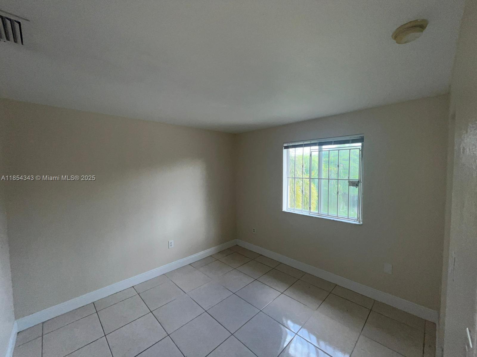 2251 Northwest 136th Terrace, Unit 2251 Opa-Locka, FL 33054 - Photo 13 of 20 an empty room with a window