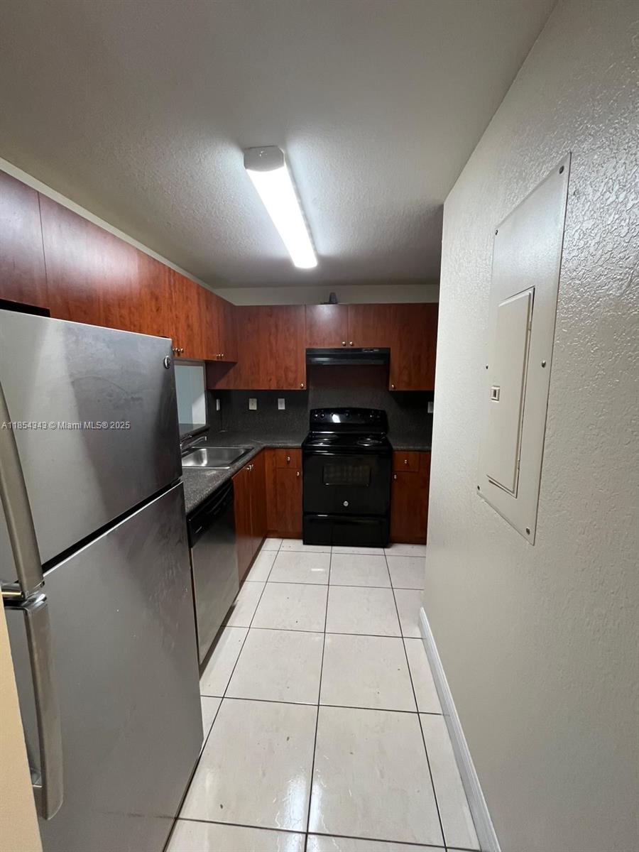 2251 Northwest 136th Terrace, Unit 2251 Opa-Locka, FL 33054 - Photo 6 of 20 a kitchen with granite countertop stainless steel appliances a sink and cabinets
