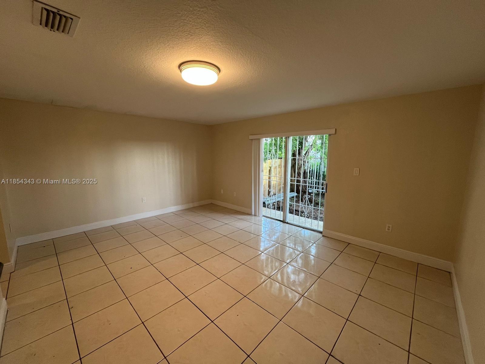 2251 Northwest 136th Terrace, Unit 2251 Opa-Locka, FL 33054 - Photo 10 of 20 a view of an empty room and window