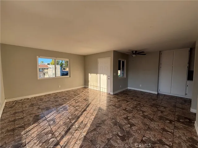a view of a big room with window and wooden floor