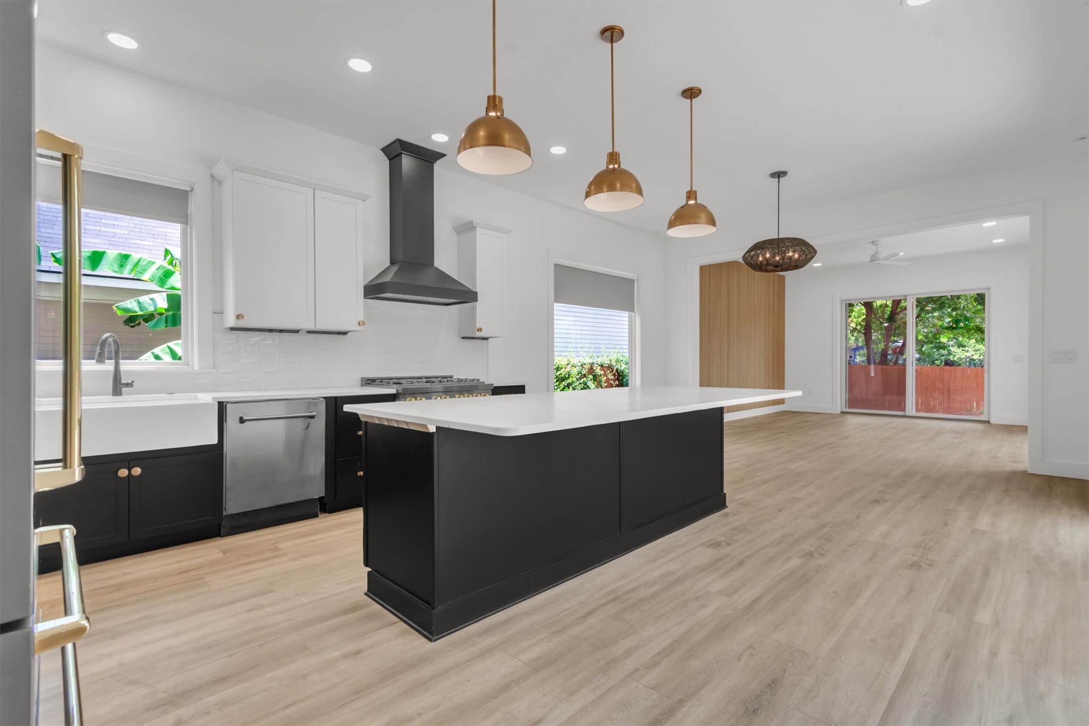 3101 Lyons Road Austin, TX 78702 - Photo 7 of 40 Modern kitchen with sleek dark cabinetry, white countertops, and luminous pendant lighting.