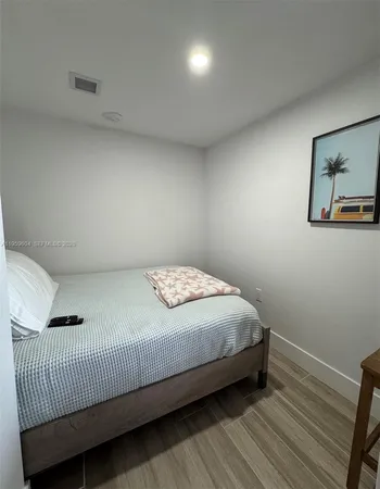 a bedroom with a bed and a painting on the wall