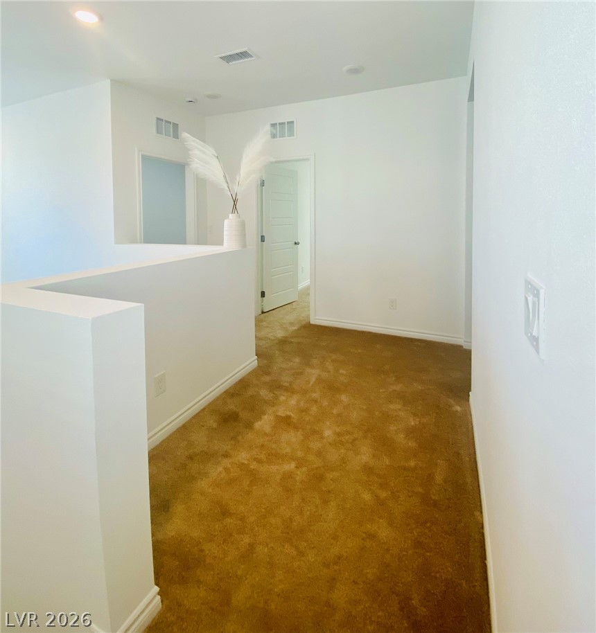4457 Sawyer Ridge Street Las Vegas, NV 89147 - Photo 19 of 32 Bright hallway with plush carpeting and modern lighting.