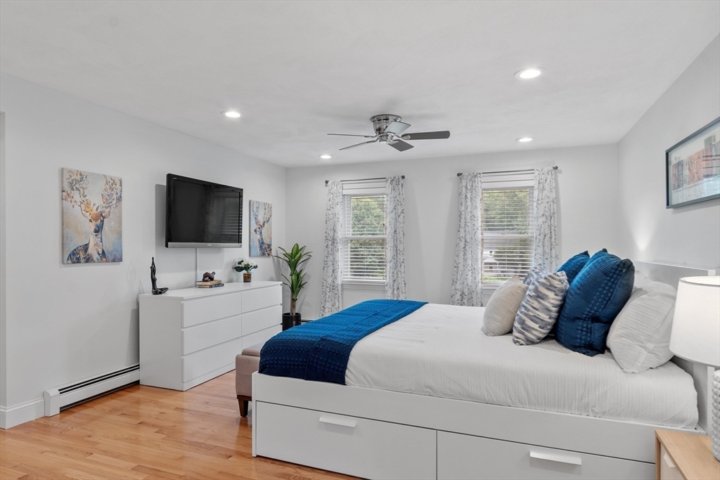 106 Reed Farm Road Boxborough, MA 01719 - Photo 17 of 40 a bedroom with a large bed and a flat tv screen on dresser