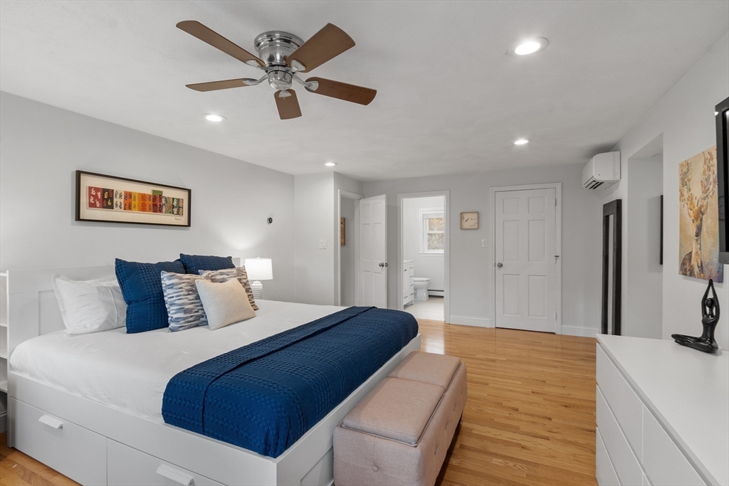 106 Reed Farm Road Boxborough, MA 01719 - Photo 18 of 40 a bedroom with a large bed and a chandelier