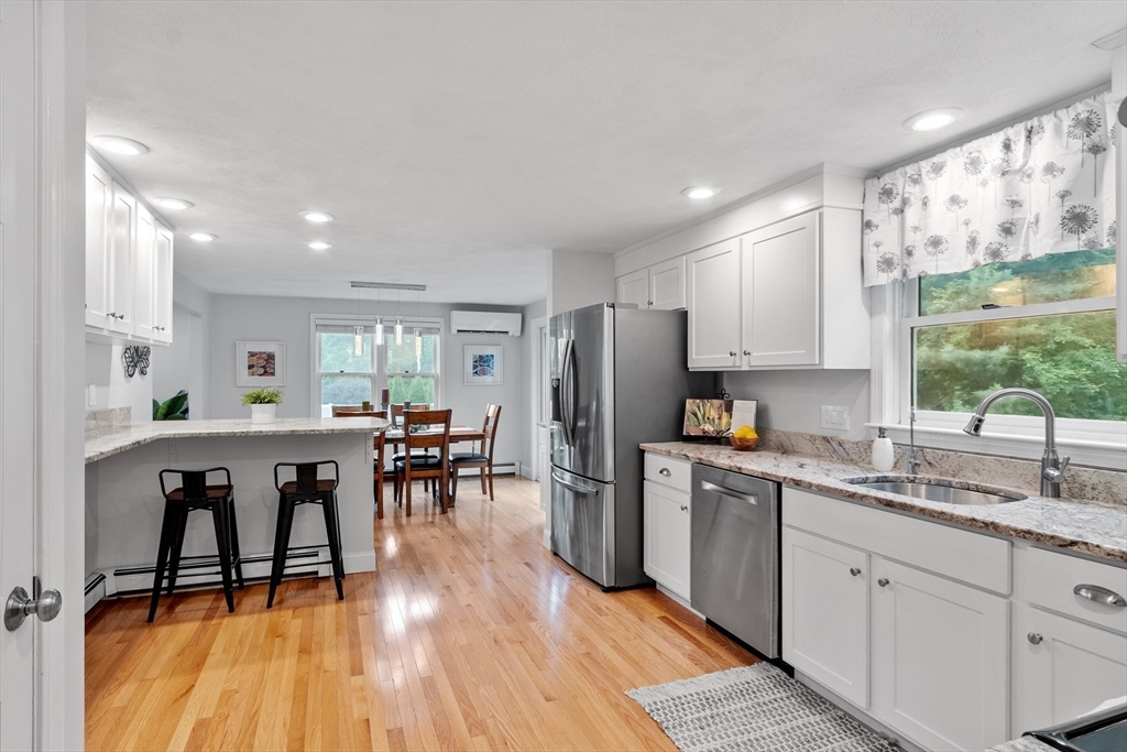 106 Reed Farm Road Boxborough, MA 01719 - Photo 3 of 40 a kitchen with stainless steel appliances granite countertop a refrigerator a sink a stove and white cabinets with wooden floor