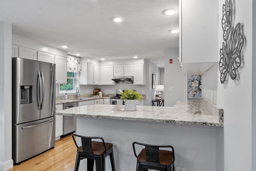 106 Reed Farm Road Boxborough, MA 01719 - Photo 4 of 40 a kitchen with stainless steel appliances granite countertop a dining table chairs refrigerator and sink