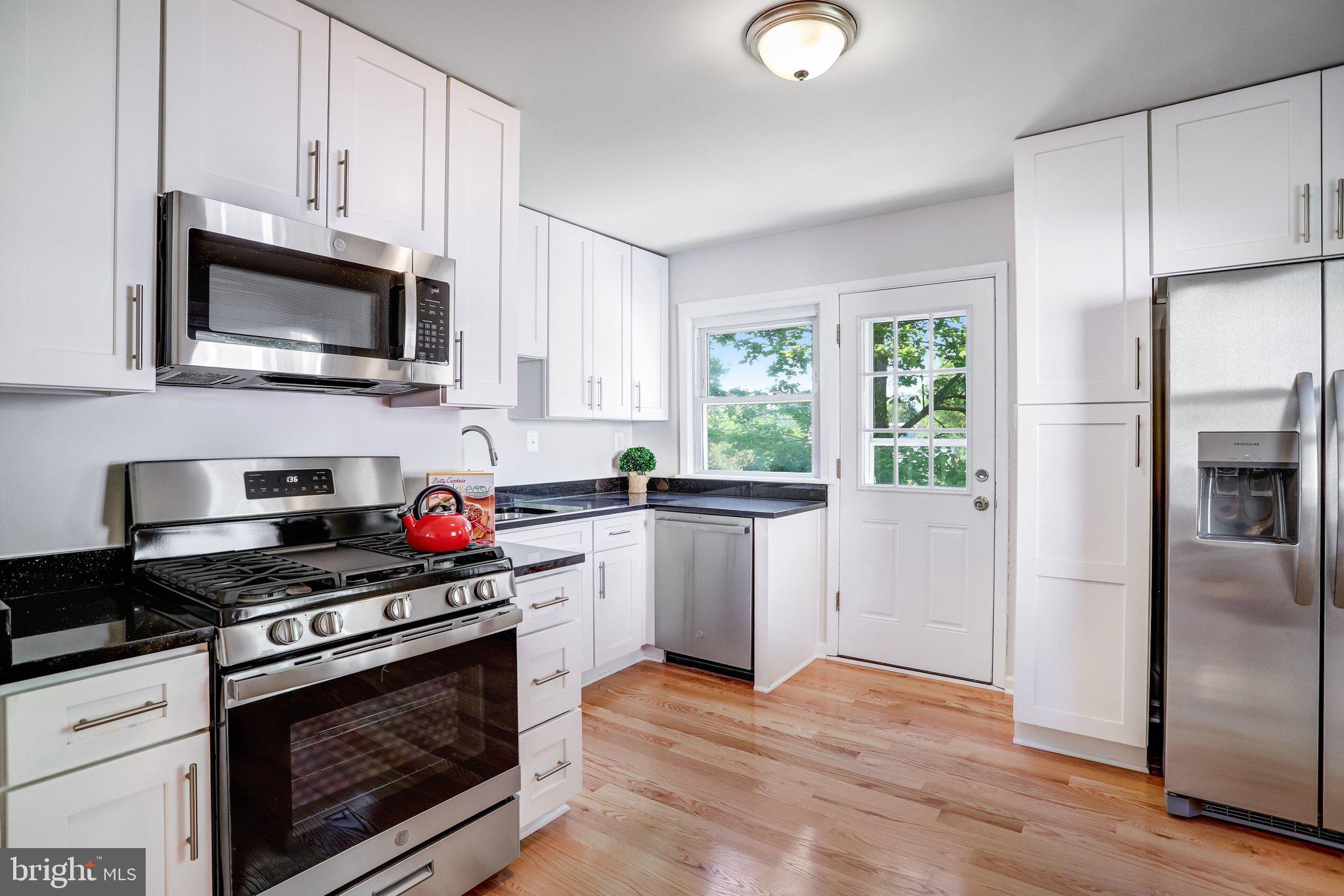 616 Ritchie Avenue Silver Spring, MD 20910 - Photo 12 of 37 a kitchen with stainless steel appliances granite countertop a stove a microwave and a refrigerator