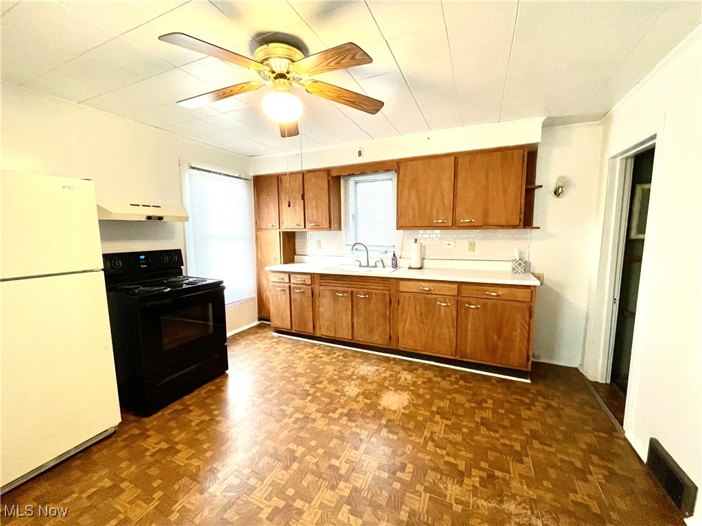 495 5th Street Struthers, OH 44471 - Photo 8 of 26 Kitchen featuring dark parquet flooring, sink, electric range, white fridge, and ceiling fan