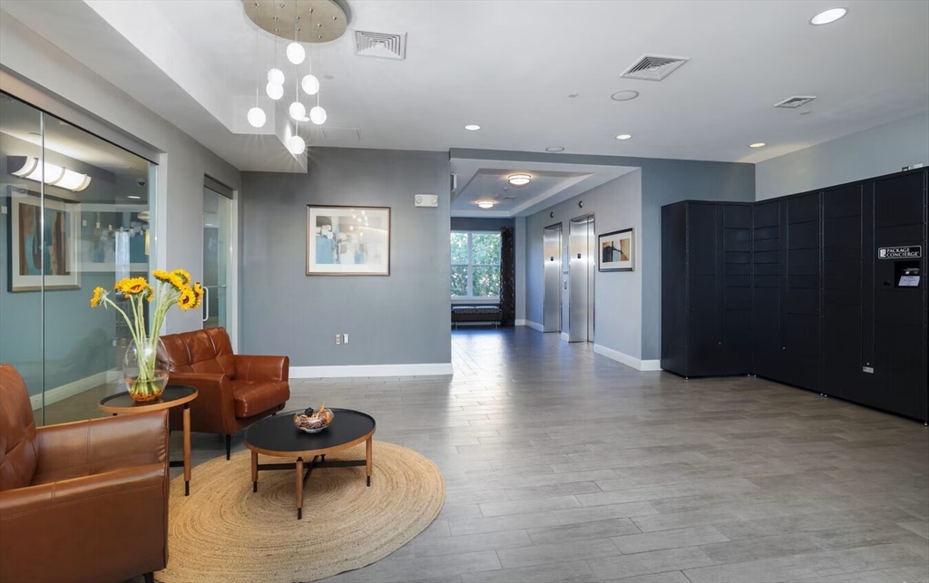 30 Mill Street, Unit 105 Arlington, MA 02476 - Photo 12 of 33 a living room with furniture and a chandelier