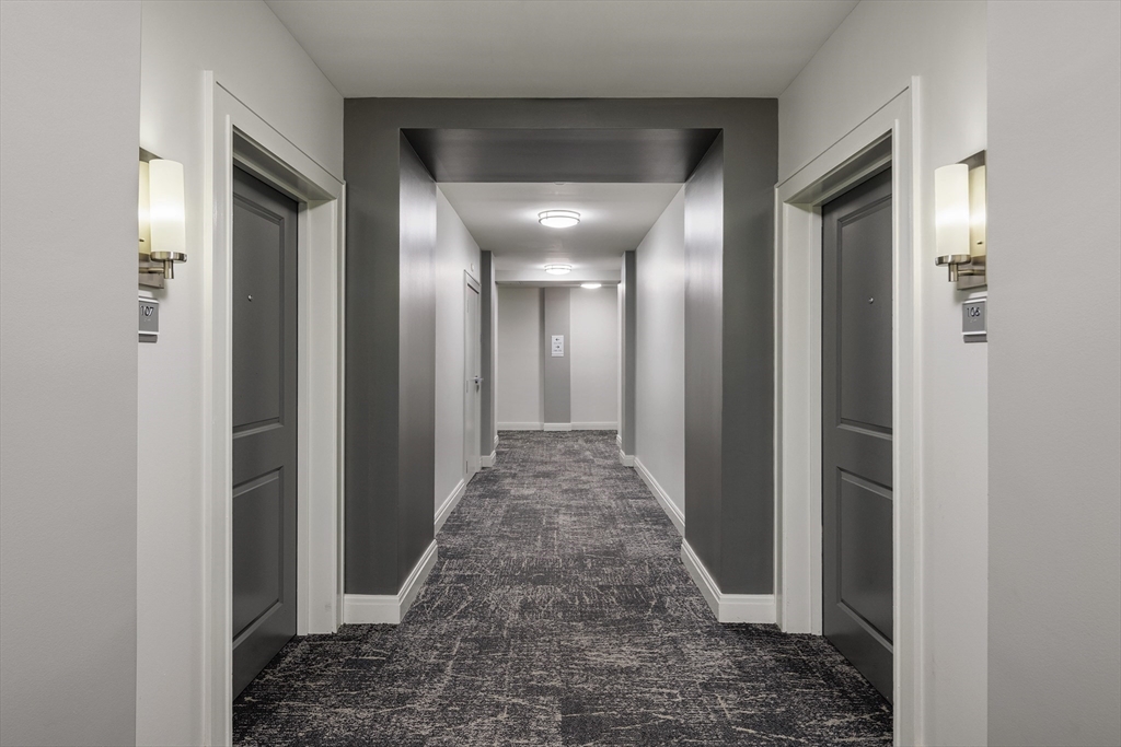 30 Mill Street, Unit 105 Arlington, MA 02476 - Photo 14 of 33 a view of a hallway with wooden floor and a bathroom