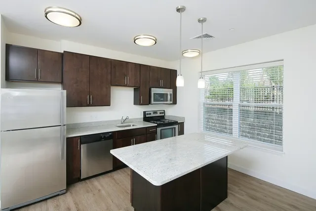 a kitchen with refrigerator cabinets and wooden floor