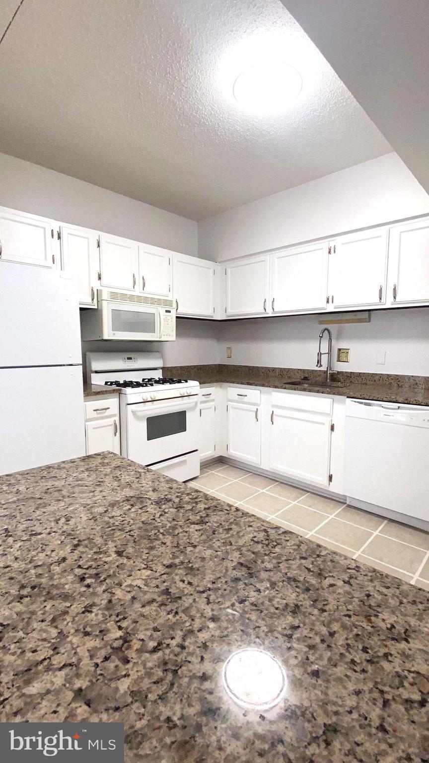 11839 Shire Court, Unit 2C Reston, VA 20191 - Photo 21 of 60 a kitchen with granite countertop a stove a sink and a refrigerator
