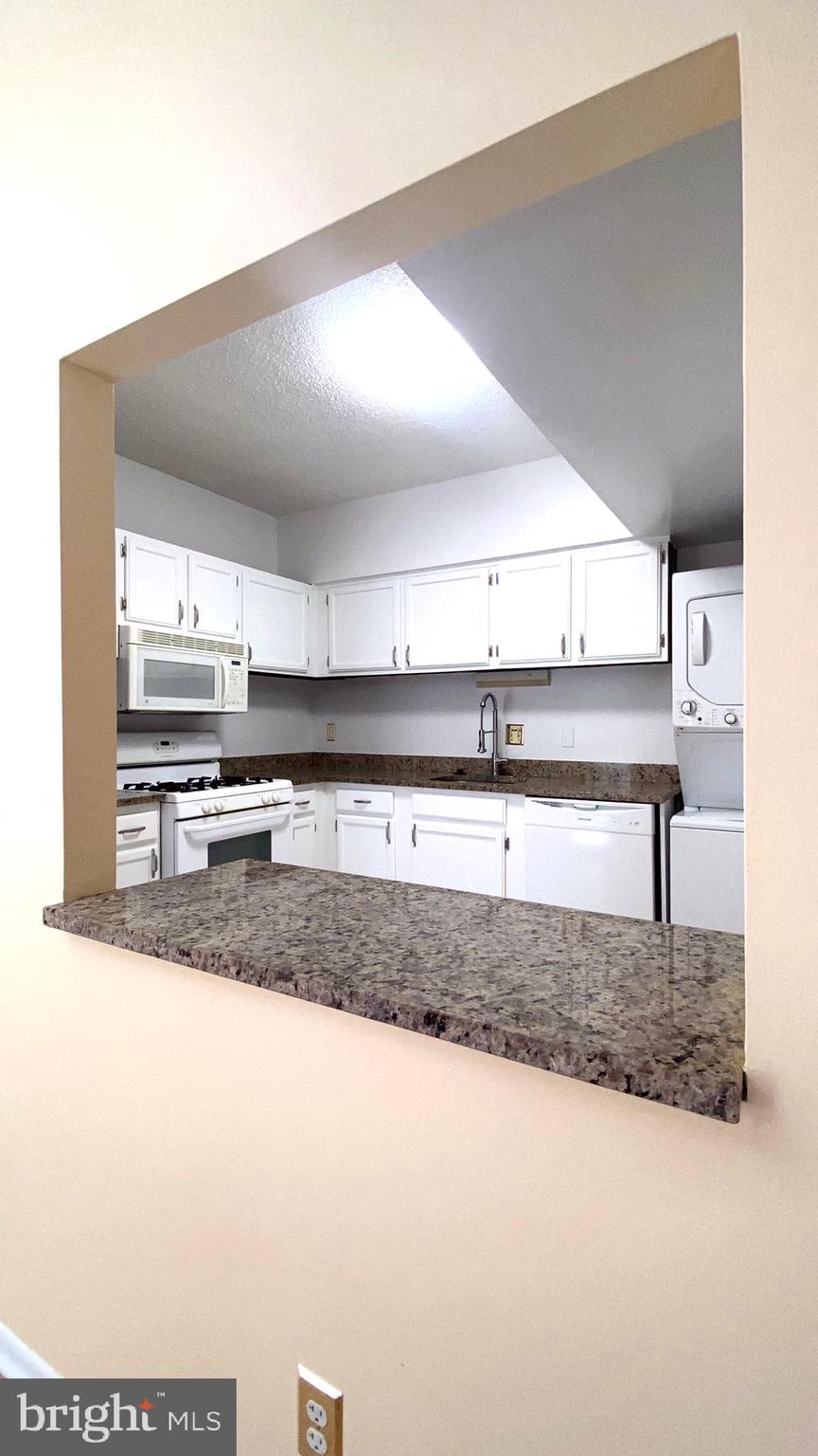 11839 Shire Court, Unit 2C Reston, VA 20191 - Photo 47 of 60 a kitchen with kitchen island a sink and a stove