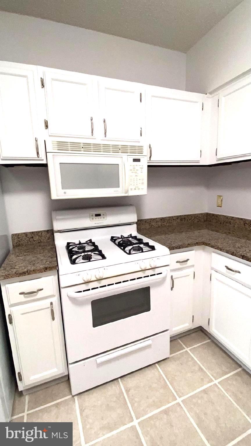 11839 Shire Court, Unit 2C Reston, VA 20191 - Photo 56 of 60 a white stove top oven sitting inside of a kitchen